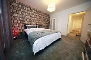 una camera da letto con un letto grande e una parete di libri di Cozy Studio (102) close to Cornavin Train Station a Ginevra Altre 8 foto