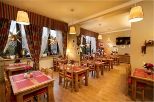 a restaurant with wooden tables and chairs and christmas decorations at Hotel Promien in Skarżysko-Kamienna