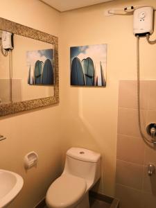 a bathroom with two pictures of surfboards on the wall at Cagayan de oro condo rentals 21 in Cagayan de Oro