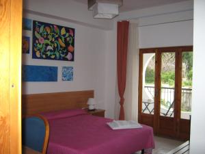 a bedroom with a purple bed and a balcony at Al Saliceto Hotel in Patti +103 photos