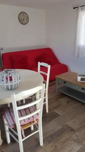 a living room with a table and a red couch at 1262 Chemin des Pignatelles in La Motte