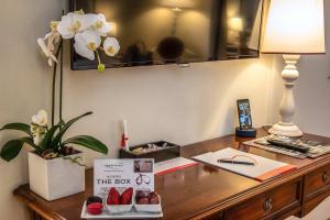 a desk with a lamp and a box of strawberries on it at Donna Camilla Savelli - VRetreats in Rome