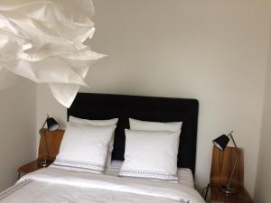 een slaapkamer met een bed met witte lakens en een zwart hoofdeinde bij L appartement des bords du Cher in Saint-Aignan