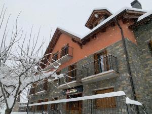 ein Gebäude mit Schnee auf dem Dach in der Unterkunft Apartamentos Maladeta in Benasque