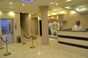 a man standing behind a counter in a lobby at شقق زهرة نادين للشقق المخدومة in Tabuk