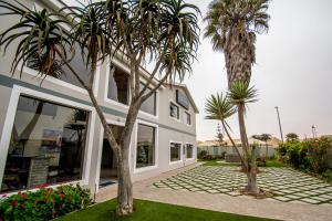 une maison avec des palmiers devant elle dans l'établissement Sea View Bliss Guesthouse with self Catering, à Swakopmund