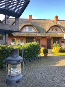 a brick house with a fountain in front of it at "Netzboden" by Ferienhaus Strandgut in Born