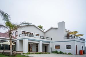 a large white house with a palm tree at Sea View Bliss Guesthouse with self Catering in Swakopmund