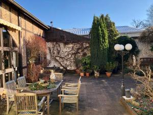 eine Terrasse mit Tisch und Stühlen und ein Gebäude in der Unterkunft Hotel Hilgers in Düren - Eifel
