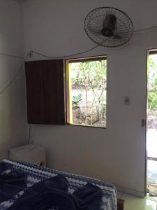 a bedroom with a bed and a window and a fan at Suite Airuma in Moreré