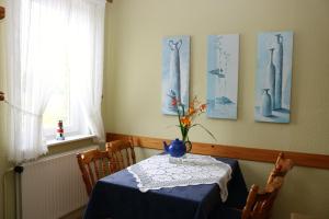 a dining room with a table with a vase on it at Romantischer Winkel in Neuharlingersiel