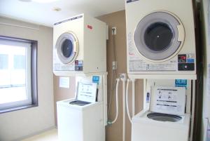 uma lavandaria com uma máquina de lavar roupa e uma máquina de lavar roupa em Sotetsu Fresa Inn Nagano-Ueda em Ueda