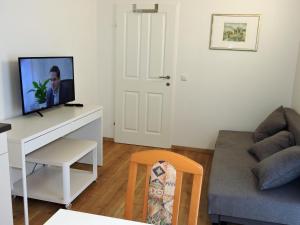 salon z kanapą i telewizorem na biurku w obiekcie 215 Apartment Wien 4-6 Pers 42m2 w mieście Klagenfurt