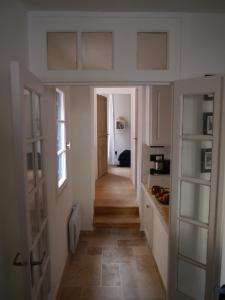 a hallway leading to a kitchen with white cabinets at Aux 4 FONTAINES in Narbonne