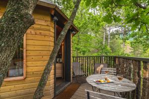 a wooden deck with a table and chairs on a cabin at Ferme Fortia in Montréal-les-Sources