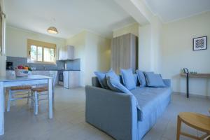 een woonkamer met een bank en een keuken bij Hilltop Residences in Kalamaki