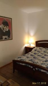 1 dormitorio con 1 cama y una foto en la pared en Casa a Soliera, en Il Cristo