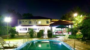 a swimming pool in front of a house at night at Cuca Legal Hotel in Presidente Figueiredo +16 photos