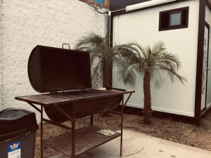 - un barbecue installé à côté d'un palmier dans l'établissement Surfari Punta Rocas, à Punta Negra