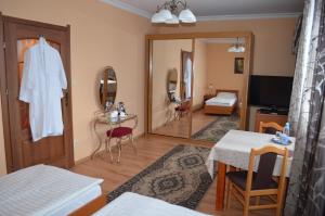 ein Wohnzimmer mit einem Spiegel und ein Schlafzimmer in der Unterkunft Hotel Olimp in Chojnice
