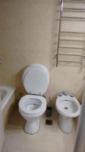 y baño con aseo blanco y lavamanos. en Ex Loi Suites Arenales en Buenos Aires