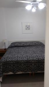 a bedroom with a bed and a ceiling fan at Ex Loi Suites Arenales in Buenos Aires