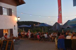 a crowd of people sitting at tables outside of a building at Naturfreundehaus Veilbronn in Heiligenstadt