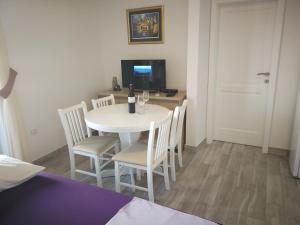 a dining room with a white table and chairs at Adriatic - Apartment with jacuzzi in Sobra