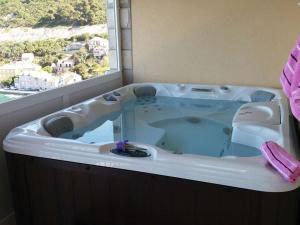 a jacuzzi tub in a bathroom with a window at Adriatic - Apartment with jacuzzi in Sobra