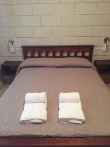 Una cama con dos toallas encima. en Casa Nuova Depto DOS y TRES en Villa María