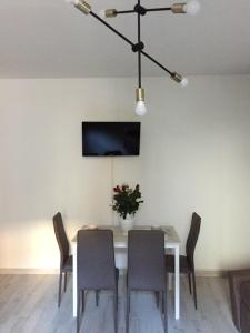 uma mesa de jantar com cadeiras e uma televisão na parede em LA CASA DI CHICCO E GINNY em Verona