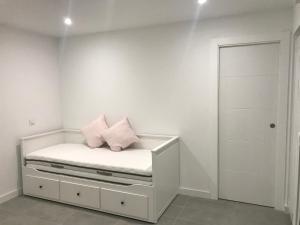 a white room with a bed with pink pillows on it at Casa en CARABAÑA a 30 minutos de MADRID in Carabaña +23 photos