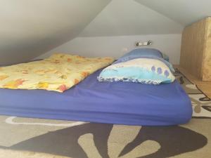 a blue bed with a pillow on top of it at Agro Breza domek nad samym jeziorem- sauna ogrodowa in Lipusz