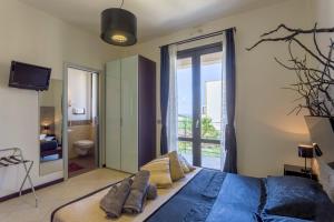 a bedroom with a large bed and a balcony at Karma B&B in San Vito lo Capo