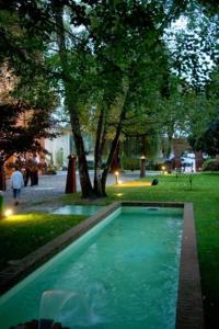 basen wodny w parku z drzewami w obiekcie Relais Del Castello Di Oviglio w mieście Oviglio