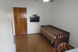1 dormitorio con 1 cama y TV en la pared en Esmeralda en Buenos Aires