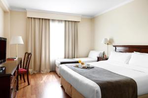 a hotel room with two beds and a television at Cyan Américas Towers Hotel in Buenos Aires