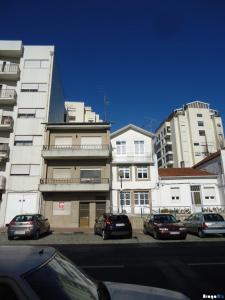 a street with cars parked in front of tall buildings at Avenida apartment 1,2 e 3 in Braga