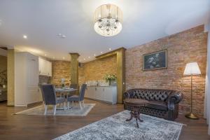 维尔纽斯Kesminta Apartments的配有皮沙发和桌子的客厅