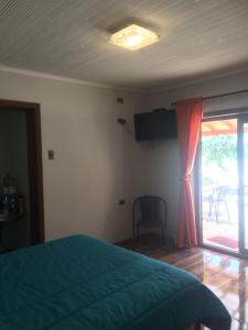 um quarto com uma cama e uma porta de vidro deslizante em Quinta el Rosal em Parral
