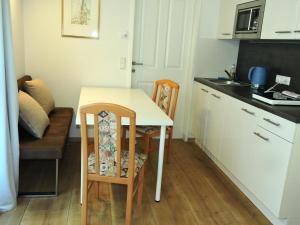 una pequeña cocina con mesa y sillas en una habitación en 215 Apartment Wien 4-6 Pers 42m2, en Klagenfurt