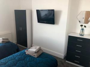 a bedroom with a bed and a tv on the wall at 'Park House' in Chorley