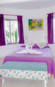 Un dormitorio con una cama con dos cisnes. en Cabañas y Apart Utopia en Mar de las Pampas