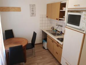 AB Apartment Objekt 24 في شتوتغارت: مطبخ صغير مع طاولة وثلاجة