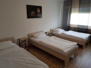 um quarto com três camas e uma janela em AB Apartment Objekt 24 em Stuttgart