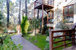 Una pasarela que conduce a una casa con balcón en Cabañas y Apart Utopia en Mar de las Pampas