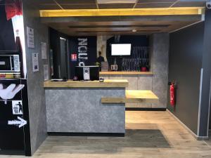 a bar with a counter with a tv in a room at ibis budget Dieppe Centre Port in Dieppe