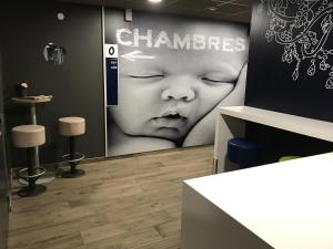 a room with a poster of a baby on the wall at ibis budget Dieppe Centre Port in Dieppe