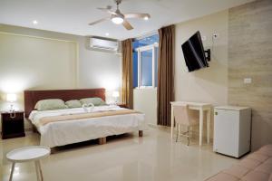 1 dormitorio con 1 cama y TV en LC Hoteles Piura, en Piura