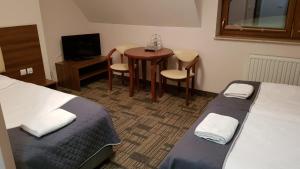 a hotel room with two beds and a small table and a table at Centrum Promocji Leśnictwa w Mucznem in Lutowiska